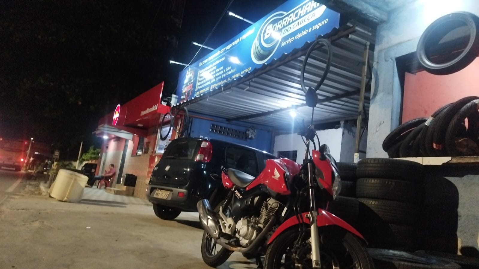 Fachada da Borracharia do Cabeça em Maceió com carro e moto